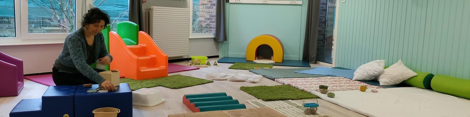 Anne, psychomotricienne, aménage la salle pour la séance de motricité libre